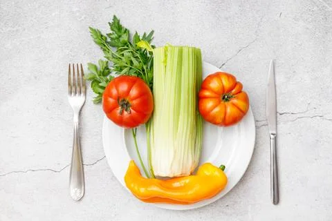Clean eating. Top view of vegetables in a plate. Tomatoes, parsley, celery .. Stock Photos