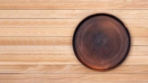 Clean empty brown ceramic textured plate on wooden table background Stock Photos