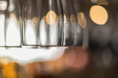 Clean empty glasses hanging from a bar rack. space for lettering copy text Stock Photos