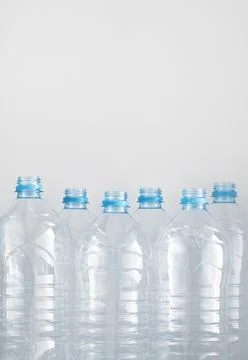 Clean empty plastic water bottles on table - recycling and food storage conce Stock Photos
