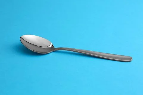 Clean empty table spoon on blue background Stock Photos