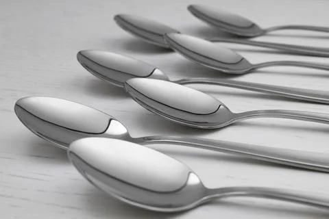 Clean empty table spoons on white wooden background Stock Photos