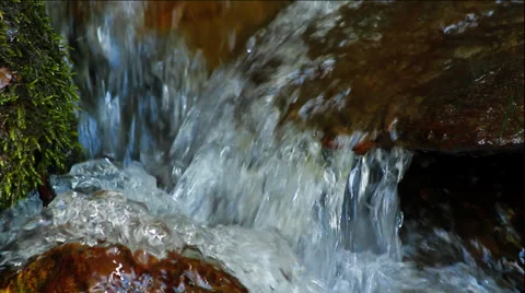Clean fresh water of a forest stream running over mossy rocks Video stock 34307099