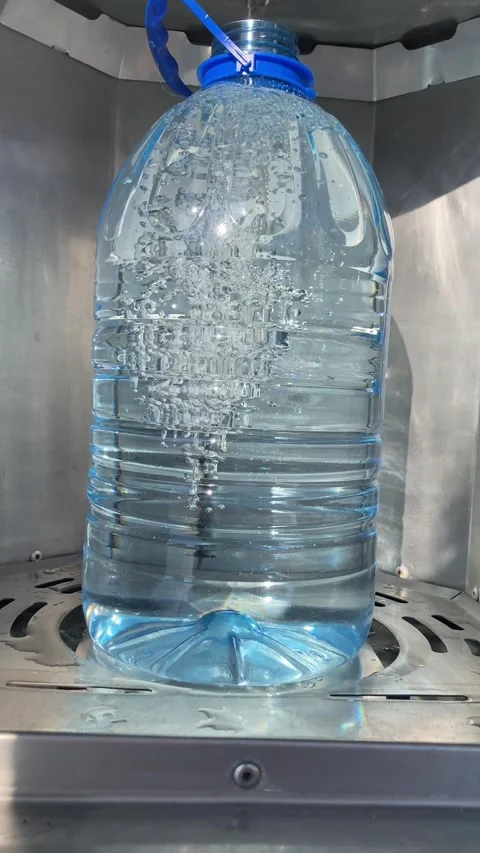 Clean fresh water is poured into a five-liter plastic bottle. Stock Footage 277935221