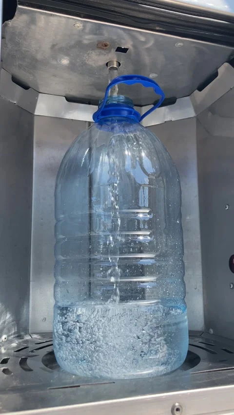 Clean fresh water is poured into a five-liter plastic bottle. Stock Footage 277935227