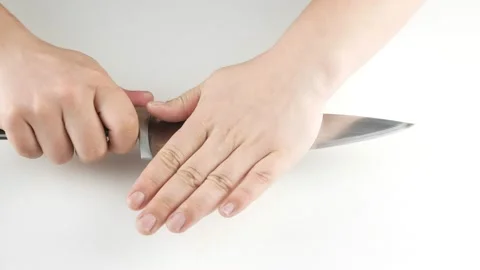 Clean garlic on a white table.Crushes head with a kitchen knife. Stock-Footage 136285079