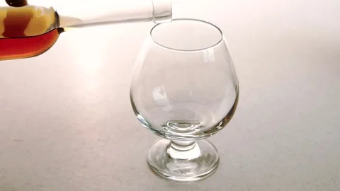 The clean glass is being fulled with high quality gold brandy in the restaurant. Stock Footage 82237831