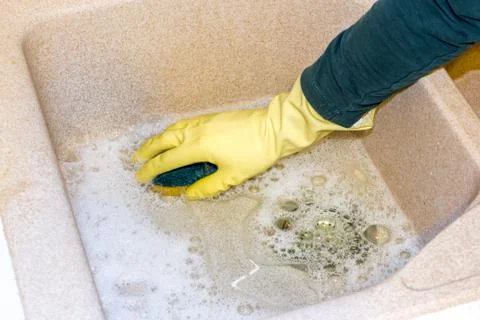 Clean a granite sink with a sponge Stock Photos