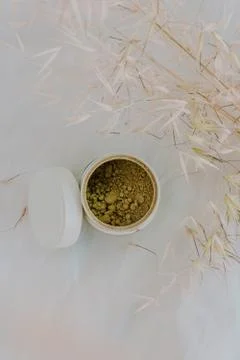Clean image of matcha tea in a pot with some dried plants and white backgroun Stock Photos