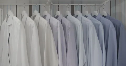 Clean ironed men's shirts set in colors hanging on hangers in the wardrobe flat Video stock 59741942