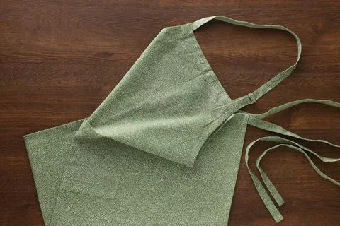 Clean kitchen apron with pattern on wooden table, top view Stockfoto's