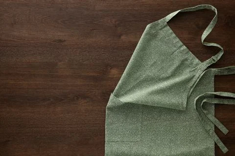 Clean kitchen apron with pattern on wooden table, top view. Space for text Stockfoto's