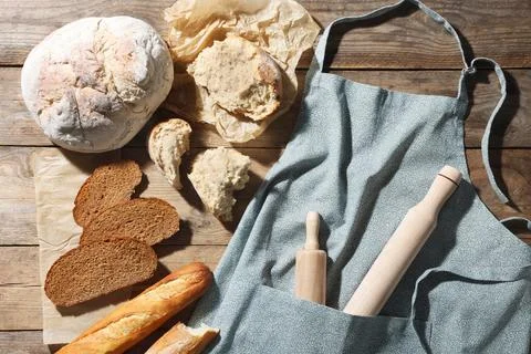 Clean kitchen apron with rolling pins and different types of bread on woode.. Stock Photos