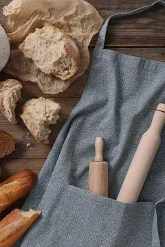 Clean kitchen apron with rolling pins and different types of bread on woode.. Stock Photos