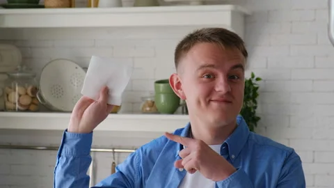 Clean kitchen. Man shows a clean white towel after measuring dust Stock Footage 128253932