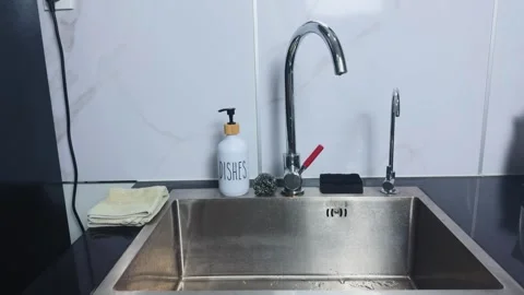 Clean kitchen sink area featuring a metal faucet, dish soap bottle, and cleaning 스톡 동영상 341862376