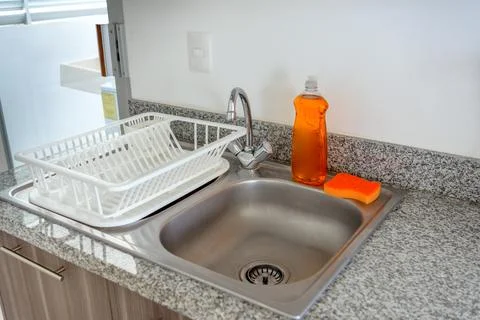 Clean kitchen sink with dish rack and soap dispenser Stock Photos