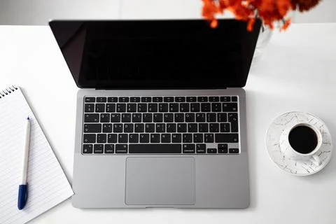 Clean laptop flat lay with pen and coffee on white desk Stock Photos