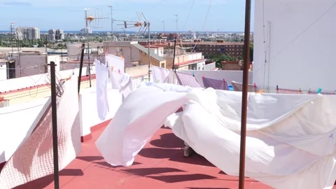 Clean laundry drying in the wind and sun on the roof of the house Stock Footage 285667201