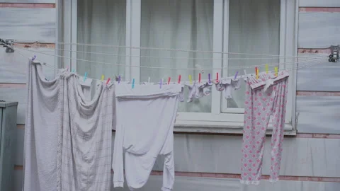 Clean laundry swaying on clothesline drying in gentle breeze Stock Footage 293139808