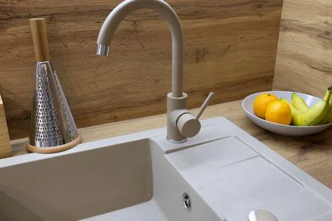 Clean lines create a modern kitchen atmosphere, with a stylish faucet next .. Stockfoto's