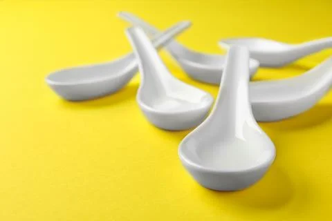 Clean Miso soup spoons on yellow background Stock Photos
