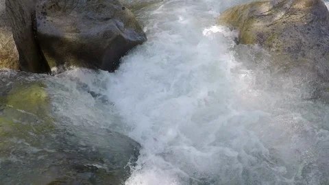 Clean mountain water runs down small mountain river over rocks and boulders Stock Footage 99674511