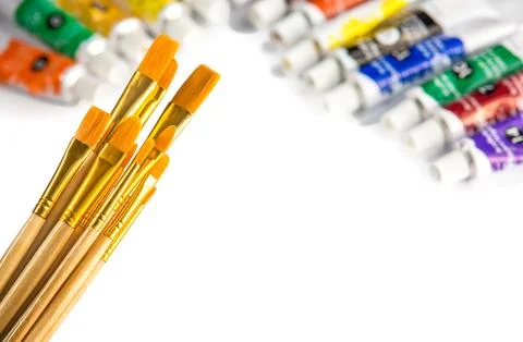 Clean new assorted sized brushes and acrylics, artist palette, against white Stock Photos