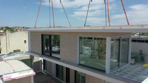 Clean new modern modular home framework suspended from crane life aerial Stock Footage 162403009