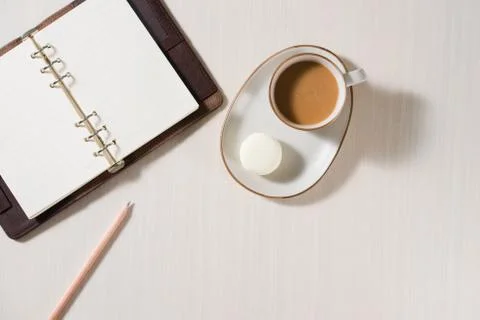 Clean notebook, cup of coffee and colorful macaron on gray desk top view. Coz Fotos Stock
