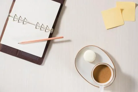 Clean notebook, cup of coffee and colorful macaron on gray desk top view. Coz Fotos Stock
