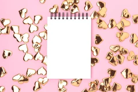 Clean notepad mockup with gold colored hearts confetti. Stock Photos