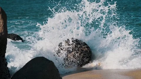 Clean ocean wave water, splash splatter, hit the big rock, shells on sand beach Stock Footage 273795209