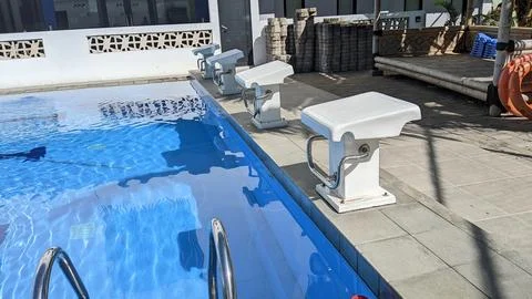 Clean outdoor pool with diving starting block Stock Photos