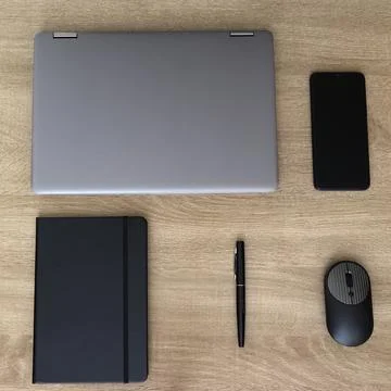 Clean overhead flat lay of closed laptop, notebook, and office supplies Stock Photos