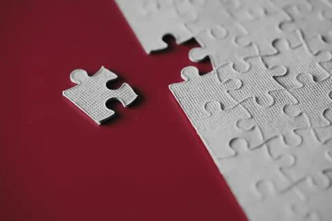 Clean puzzle elements on the red background. Empty puzzle piece on the tabl.. Stock Photos