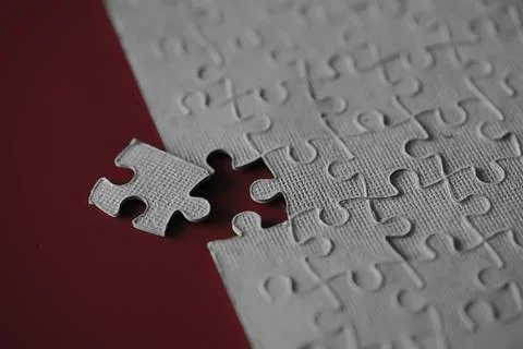 Clean puzzle elements on the red background. Empty puzzle piece on the tabl.. Stock Photos