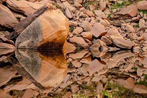 Clean reflection of rocks in a natural pool Stock Photos