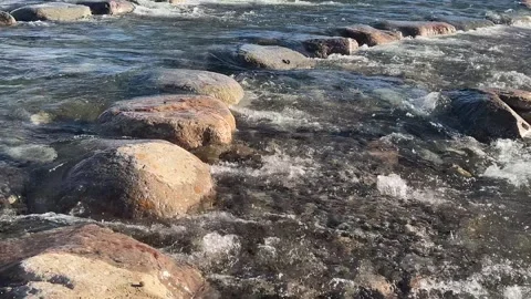 Clean river flows over boulder rapids in bright sunshine Stock Footage 273176606