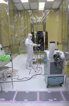 In a clean-room environment containing the AIM spacecraft (background) at ... Stock Photos
