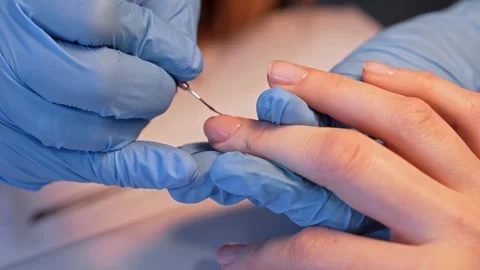 Clean salon close-up of a nail technician using a precision tool to refine a Stockbeeldmateriaal 333655558