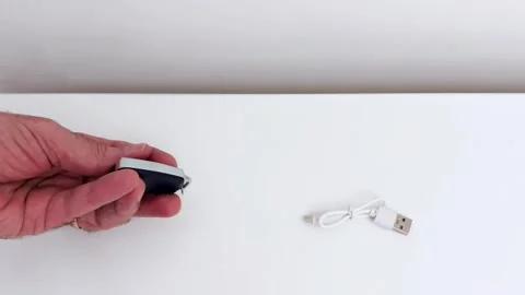 Clean Setup: USB Cable Meets Compact Gadget Video stock 318340105