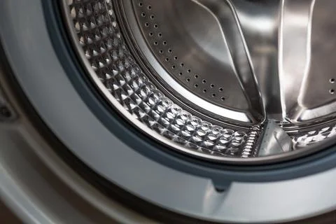 Clean shiny washing machine part of drum close-up. The concept of cleaning ap Stock Photos
