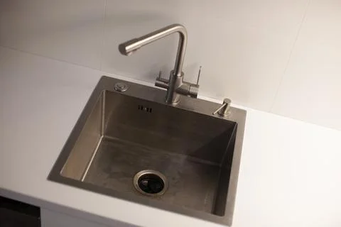 Clean sink in the kitchen. White tabletop. Stock Photos
