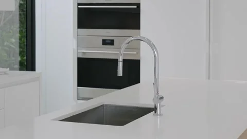 Clean sleek kitchen in minimalist design with built-in oven and stainless steel Stock Footage 262274168