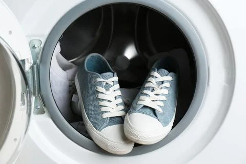 Clean sports shoes in washing machine drum Stock Photos