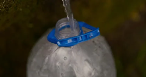 Clean spring water flowing from a natural pipe in bottle, themes ecology Stock Footage 333901765