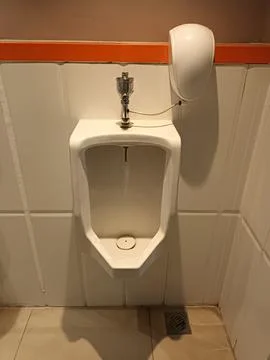 A Clean Urinal with an Automatic Flush Sensor in a Public Restroom Stock Photos