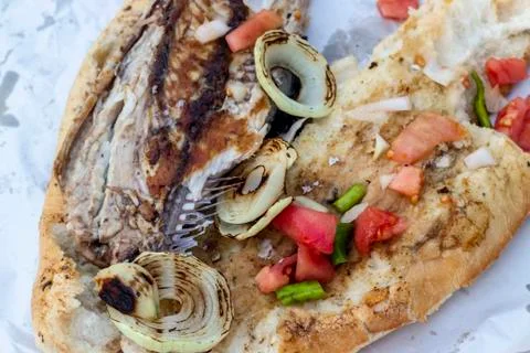 Clean view of fish and bread food with tomato, onion, pepper on the street Stock Photos