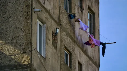 Clean washed linen dries outside the window, hung on ropes and develops in a Stock Footage 233785213